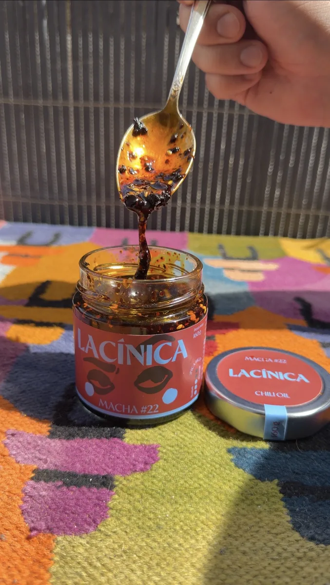 Una cuchara sacando salsa del bote abierto