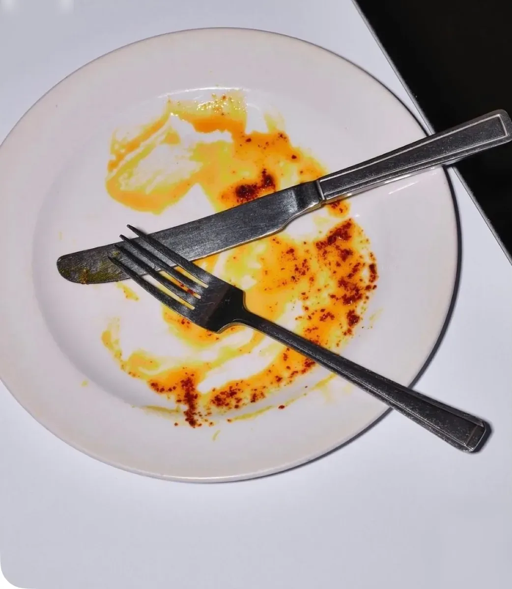 Un plato rebañado, con el cuchillo y el tenedor cruzados